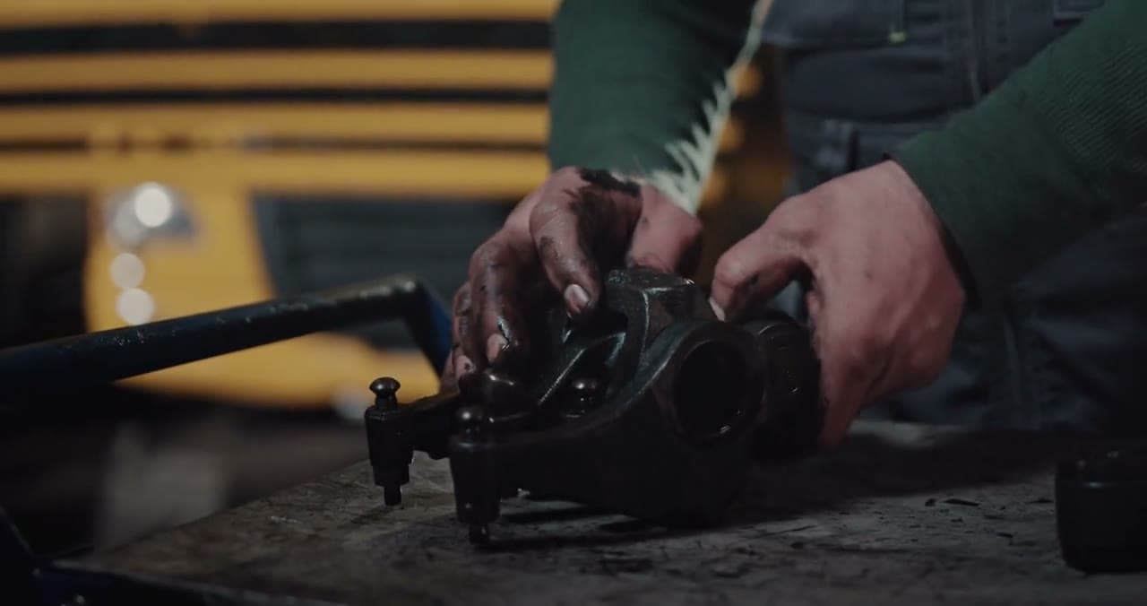 Hands separating a car part on a workbench
